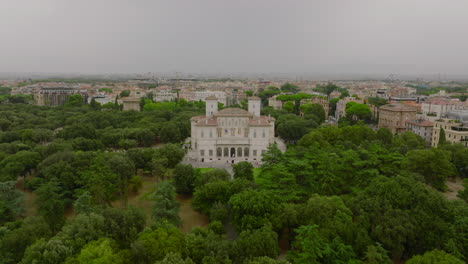 Aerial-slide-and-pan-footage-of-standalone-historic-villa-in-park,-museum-and-Galleria-Borghese.-Rome,-Italy