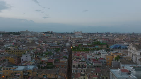 Aerial-view-of-buildings-in-urban-borough-at-dusk.-Classic-apartment-buildings-with-rooftop-terraces.-Rome,-Italy