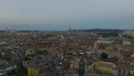 Tourist-landmarks-and-old-residential-houses-in-historic-city-centre.-Forwards-fly-above-metropolis-at-twilight.-Rome,-Italy
