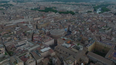 High-angle-view-of-ancient-temple-with-circular-roof,-Pantheon.-Fly-above-tourist-landmarks-in-historic-city-centre.-Rome,-Italy
