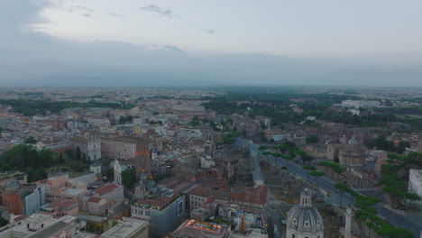 Aerial-ascending-footage-of-landmarks-in-historic-city-centre.-Several-churches-and-basilicas,-old-houses-and-famous-Colosseum.-Rome,-Italy