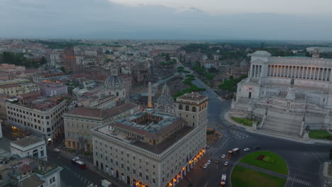 Forwards-fly-around-majestic-Vittoriano-monument-at-twilight.-Aerial-view-of-historic-city-centre,-remains-of-ancient-forums.-Rome,-Italy
