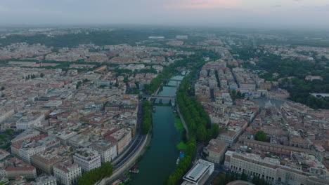 Amazing-aerial-panoramic-footage-of-metropolis.-Tiber-river-surrounded-by-green-trees-and-calm-water-surface-reflecting-bridges.-Rome,-Italy