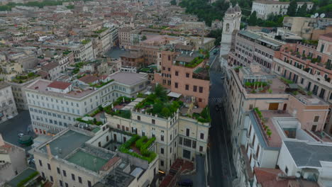 High-angle-view-of-apartment-bouses-with-green-vegetation-on-rooftop-terraces.-Forwards-fly-above-city-at-twilight.-Rome,-Italy