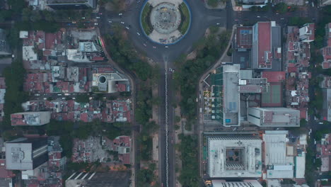 Aerial-birds-eye-overhead-top-down-panning-view-following-street-with-circular-crossroad-at-Angel-of-Independence-monument.-Mexico-city,-Mexico.