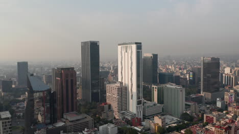 Panorama-curve-shot-of-downtown.-Flying-towards-tall-office-buildings.-Limited-visibility-due-to-air-pollution.-Mexico-City,-Mexico.