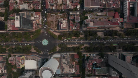 Aerial-birds-eye-overhead-top-down-view-of-heavy-traffic-in-city-streets.-Drone-camera-following-multilane-Avenida-Paseo-de-la-Reforma-street-between-tall-buildings.-Mexico-city,-Mexico.