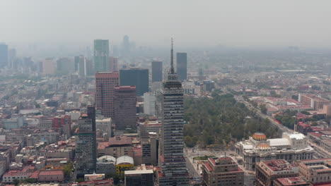 Aerial-view-of-large-town-cityscape-with-Torre-Latinoamericana-tall-building-and-Palacio-de-Bellas-Artes.-Orbiting-around-skyscraper.-Mexico-City,-Mexico.