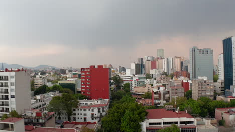 Vuelo-De-Drones-Hacia-Adelante-Sobre-Los-Edificios-Del-Barrio-Del-Centro-De-La-Ciudad-Capital-De-México-Con-Antecedentes-De-Rascacielos-De-Negocios.-Zoom-Aéreo-A-La-Vista.