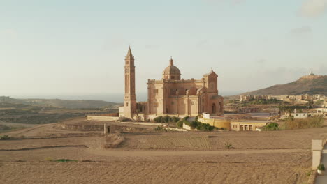 Ta-Pinu-Basilica-Castle-in-dry-Country-of-Gozo-Island,-Malta-im-Sand-Brown-color,-Beautiful-Aerial-Establishing-Shot-forward