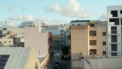Luftdrohne-Vorwärts-Durch-Die-Straße-Von-Malta-Und-über-Dächer,-Die-Das-Stadtbild-Mit-Blauem-Himmel-Und-Wolken-Enthüllen