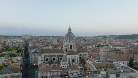 Pull-back-footage-of-San-Carlo-al-Corso-basilica.-Revealing-buildings-and-tourist-landmarks-in-city-centre-at-twilight.-Rome,-Italy