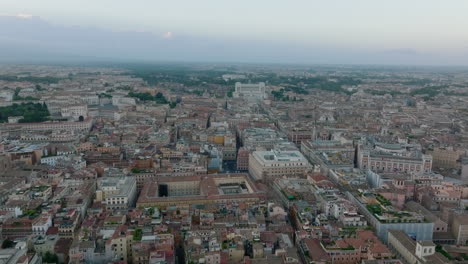 Aerial-panoramic-view-of-city-centre-with-historic-tourist-landmarks.-Fly-above-metropolis-at-twilight.-Rome,-Italy