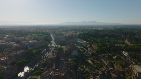 Aerial-circular-footage-of-famous-ancient-Colosseum-amphitheatre.-Well-known-historic-tourist-landmark-in-metropolis.-Rome,-Italy
