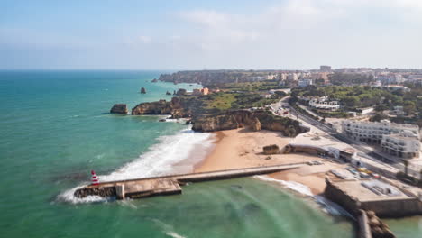 Aerial-hyper-lapse-of-Lagos-harbor-near-amazing-beach-shore-coastline,-Portugal,-drone-rising-dolly-in,-sunny-day