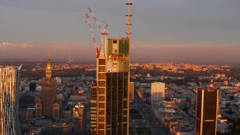 Elevated-footage-of-construction-of-new-skyscraper.-Russian-style-PKIN-building-in-background.-Warsaw,-Poland