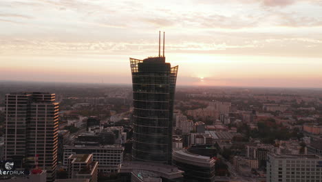 Forwards-fly-towards-modern-futuristic-high-rise-building-tower-high-above-urban-development.-Warsaw,-Poland