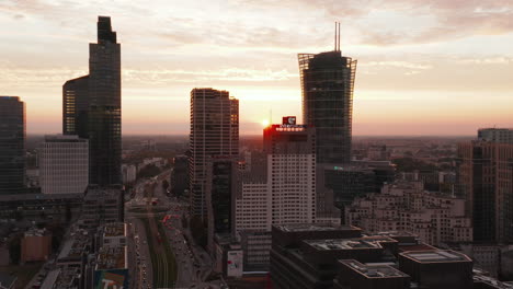 Rising-footage-of-downtown-skyscrapers-silhouette-against-colourful-sunset-sky.-Modern-high-rise-office-buildings.-Warsaw,-Poland