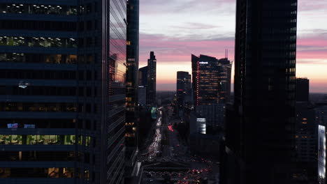 Amazing-picturesque-colourful-twilight-sky-behind-downtown-skyscrapers.-Forwards-fly-above-busy-street.-Warsaw,-Poland