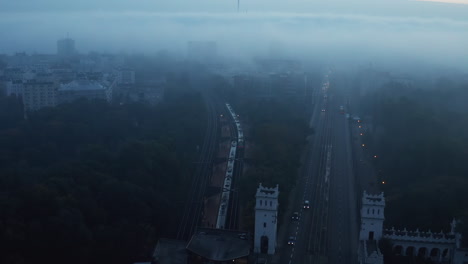 Forwards-tracking-of-regional-train-driving-through-urban-neighbourhood-in-misty-morning.-Warsaw,-Poland