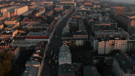 Fly-above-historic-town-centre-lit-by-morning-sun.-Large-buildings-and-palaces-at-sunrise.-Warsaw,-Poland