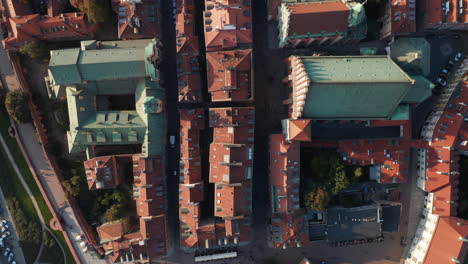 Aerial-birds-eye-overhead-top-down-panning-view-of-red-tiled-rooftops-and-squares-in-historic-centre-of-old-town.-People-walking-and-sightseeing.-Warsaw,-Poland