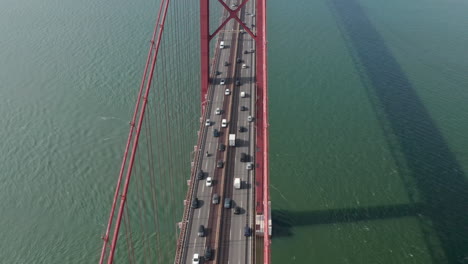 Aerial-view-of-heavy-traffic-on-multilane-highway-in-rush-hour.-Drone-flying-over-big-bridge-spanning-Tagus-river.-Lisbon,-capital-of-Portugal.