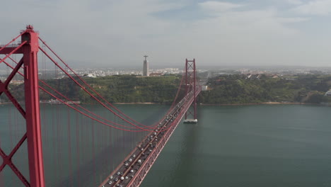Aerial-drone-view-of-long-25th-of-April-Bridge.-Heavy-traffic-on-highway.-Drone-camera-flying-over-bridge.-Lisbon,-capital-of-Portugal.