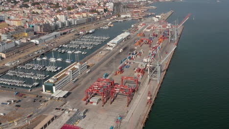 Aerial-view-of-cargo-containers-in-industrial-cargo-port-by-the-sea-near-city-center-of-Lisbon,-Portugal