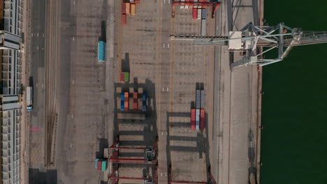 Aerial-birds-eye-overhead-top-down-panning-view-of-harbor.-Stacked-piles-of-naval-containers-for-intermodal-transport.-Drone-camera-flying-over-docks.-Lisbon,-capital-of-Portugal.