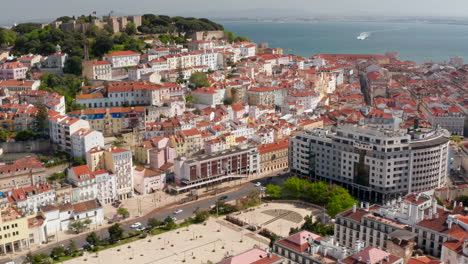 Aerial-view-medieval-stone-Saint-George-Castle-on-hill-above-Martim-Moniz-square.-Drone-camera-flying-around-castle-hill.-Lisbon,-capital-of-Portugal.
