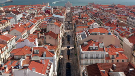 Drone-camera-flying-forward-and-following-Rua-Augusta-promenade-towards-stone-triumphal-arch-Rua-Augusta-Arch.-Lisbon,-capital-of-Portugal.