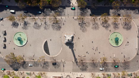 Aerial-overhead-top-down-birds-eye-view-of-people-walking-around-large-public-square-with-water-fountains-in-Lisbon-city-center
