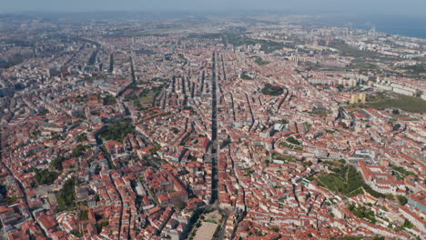 Wide-aerial-panoramic-view-of-houses-and-apartment-buildings-in-urban-city-center-of-Lisbon,-Portugal