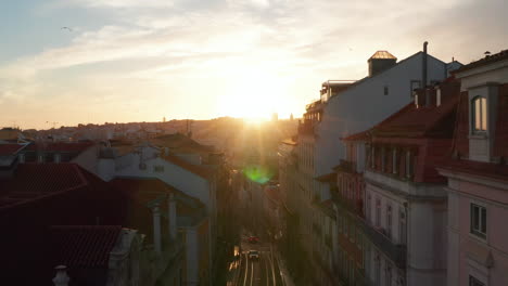 Aerial-dolly-in-view-of-the-quiet-residential-street-and-colorful-houses-in-urban-city-center-of-Lisbon,-Portugal-during-sunset
