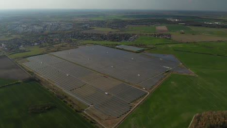 Aerial-footage-of-large-and-powerful-solar-park-near-town.-Green-energy,-ecology-and-carbon-footprint-reduction-concept