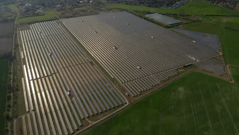 Rows-of-photovoltaic-panels-reflecting-sunshine.-Large-solar-park-built-on-field.-Green-energy,-ecology-and-carbon-footprint-reduction-concept