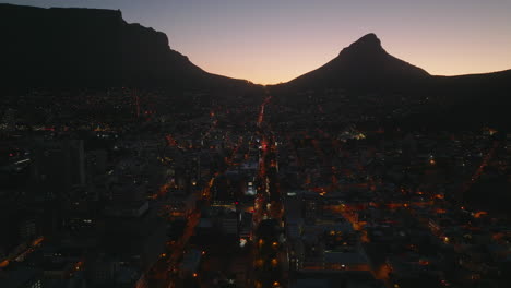 Evening-aerial-panoramic-footage-of-urban-neighbourhood.-Silhouette-of-mountain-peaks-against-colourful-twilight-sky.-Cape-Town,-South-Africa