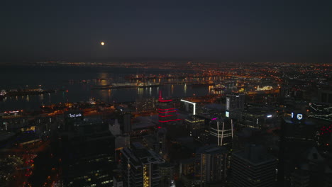 Aerial-descending-footage-of-city-centre-and-large-seaport-at-night.-Illuminated-buildings-and-street-lights.-Cape-Town,-South-Africa