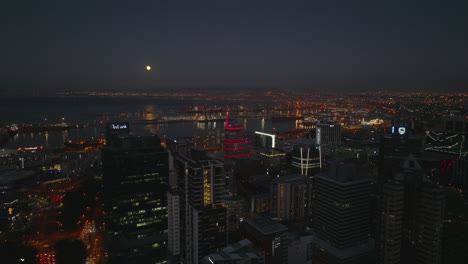 Slide-and-pan-shot-of-evening-harbour-on-in-sea-bay.-Fly-above-buildings-in-city-centre-after-sunset.-Cape-Town,-South-Africa