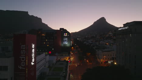 Forwards-fly-above-busy-road-in-urban-neighbourhood.-Romantic-colourful-twilight-sky.-Cape-Town,-South-Africa