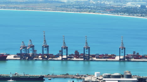 Big-cranes-and-stacked-overseas-containers-in-harbour-and-blue-water-surface.-Transport-and-logistics-concept.-Cape-Town,-South-Africa