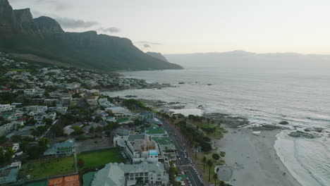 Aerial-panoramic-footage-of-tropical-summer-vacation-destination.-Luxury-resort-at-beach-and-mountain-ridge-at-twilight.-Cape-Town,-South-Africa