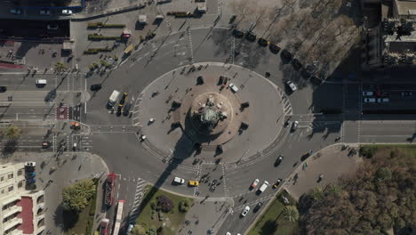 High-angle-view-of-vehicles-driving-in-streets-of-city.-Oval-roundabout-at-famous-Columbus-Monument.-Barcelona,-Spain
