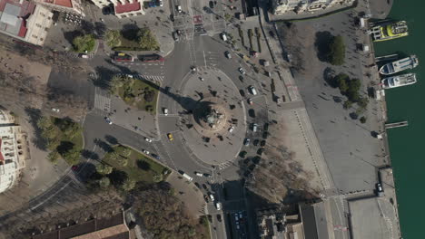Birds-eye-shot-of-large-multilane-roundabout-around-famous-landmark.-Vehicles-passing-along-Columbus-Monument.-Barcelona,-Spain