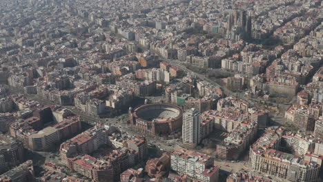 Aerial-panoramic-footage-of-town-development.-Famous-La-Monumental-arena-and-basilica-Sagrada-Familia.-Barcelona,-Spain