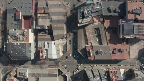 Von-Oben-Nach-Unten-Schwenkende-Aufnahmen-Von-Quadratischen-Gebäudeblöcken,-Die-An-Sonnigen-Tagen-Von-Straßen-In-Der-Stadt-Gesäumt-Sind.-Barcelona,-Spanien