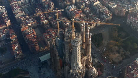 High-angle-view-of-top-of-unfinished-basilica-Sagrada-Familia.-Tower-cranes-on-construction-site-high-above-city.-Barcelona,-Spain