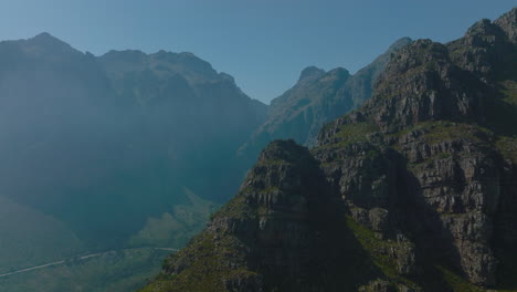 Forwards-fly-around-majestic-rocky-ridge-above-deep-valley.-Morning-shot-with-hazy-background.-South-Africa