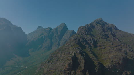 Slide-and-pan-shot-of-mountain-ridge.-Rugged-rocky-mountains-in-morning-sun-against-clear-sky.-South-Africa